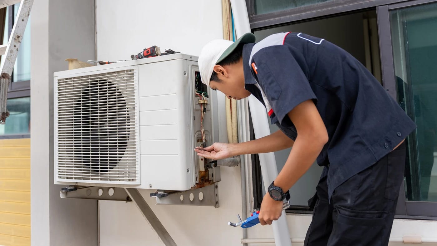 Professional AC repair technician diagnosing cooling problems in Dubai